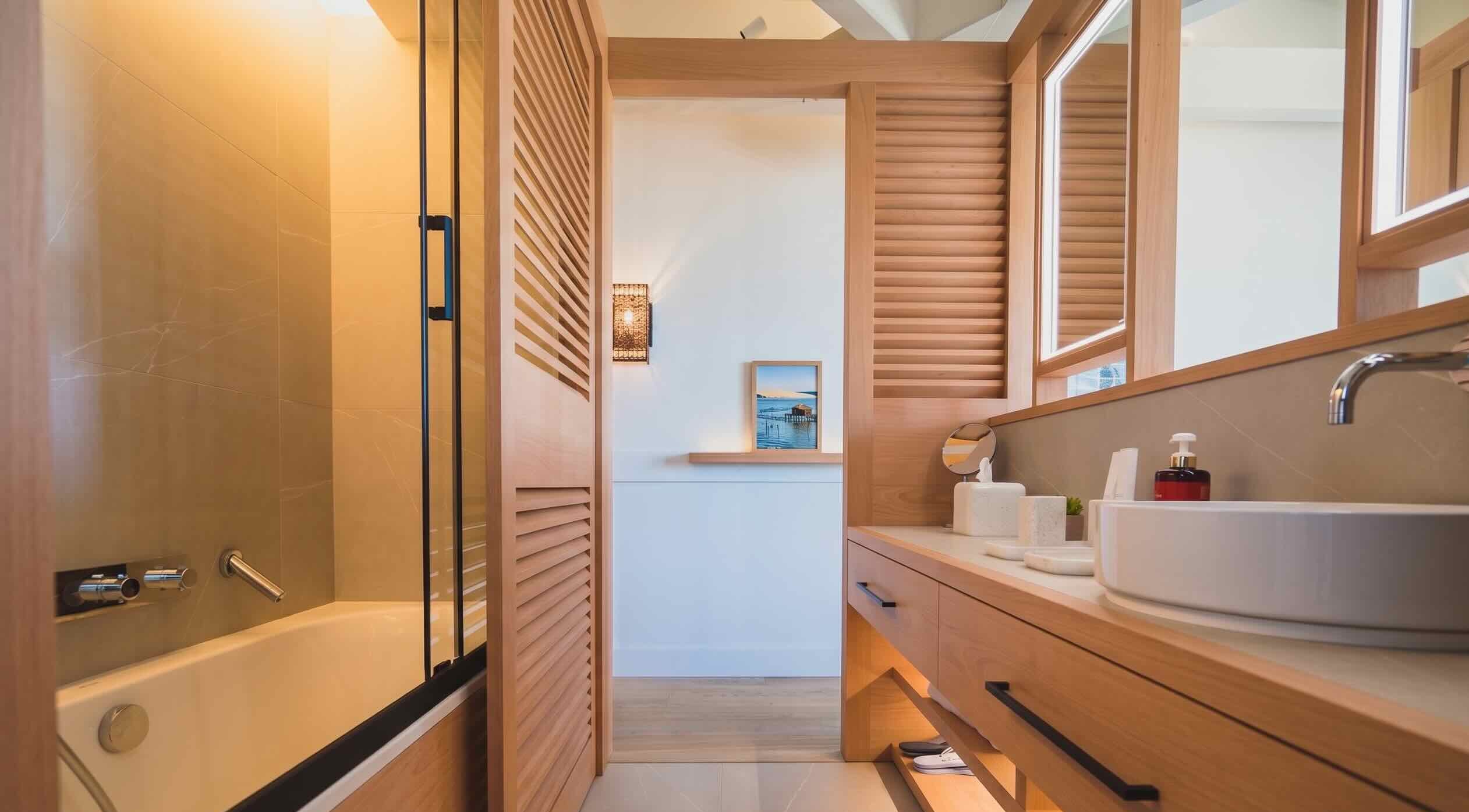 Salle de bain en bois de pin, baignoire et double vasque avec vue jardin