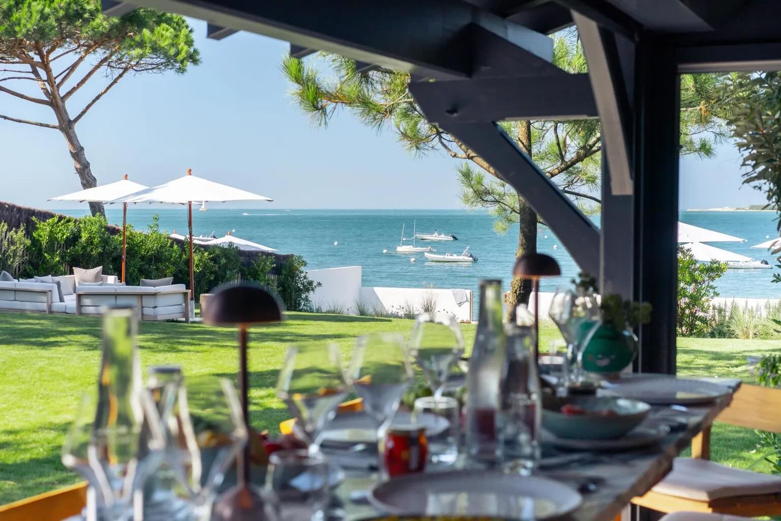 Terrasse avec repas dressé, vue sur le Bassin d'Arcachon et les bateaux