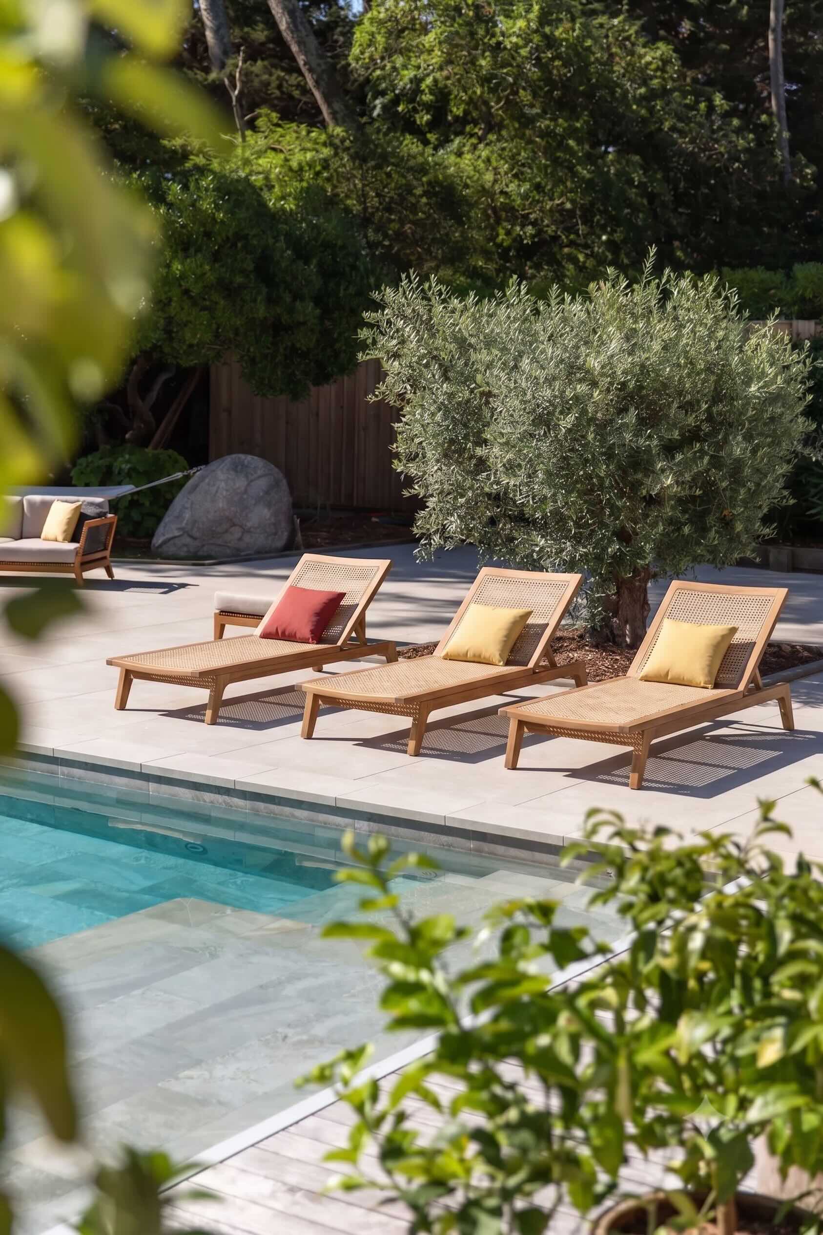 Bains de soleil en teck autour d'une piscine, oliviers et végétation méditerranéenne